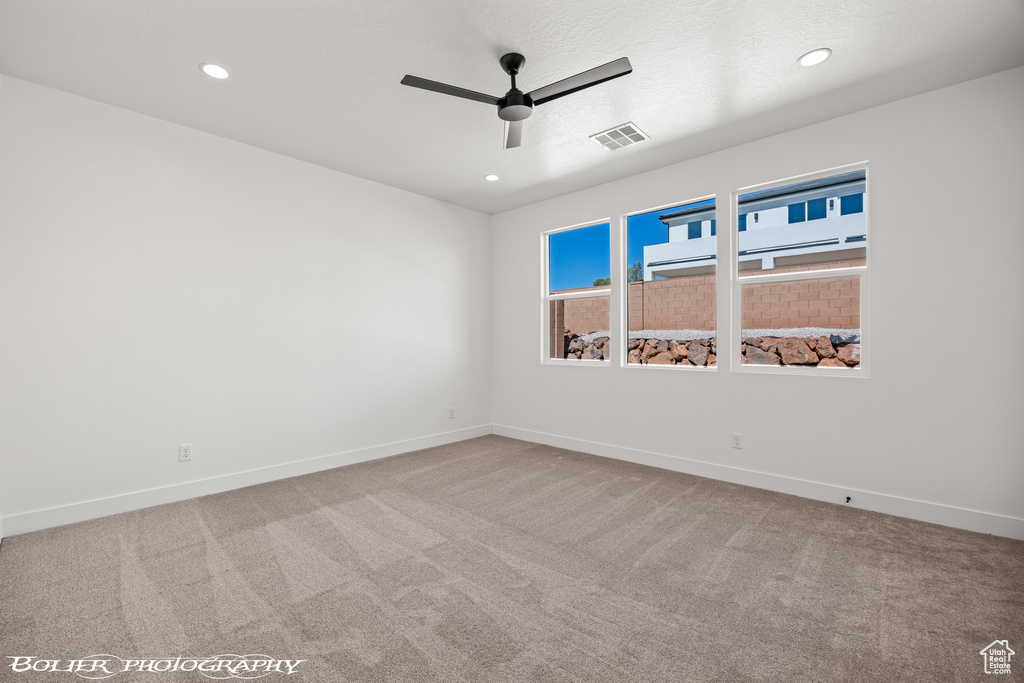 Unfurnished room featuring ceiling fan and carpet flooring