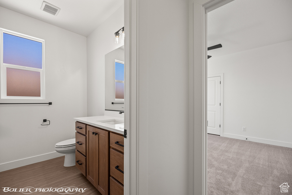 Bathroom featuring wood-type flooring, vanity, and toilet