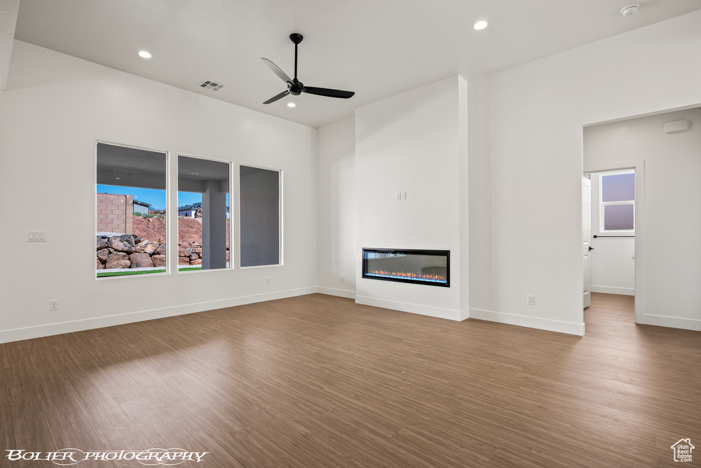 Unfurnished living room featuring ceiling fan and hardwood / wood-style floors