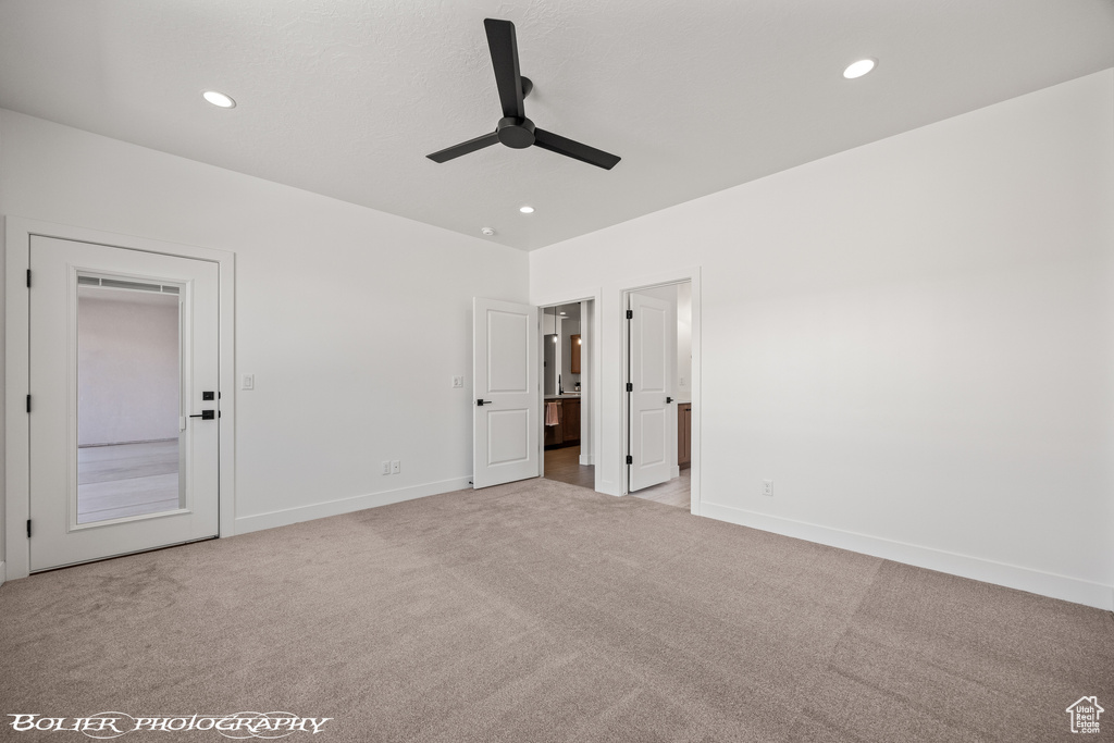 Unfurnished bedroom featuring ceiling fan and light colored carpet