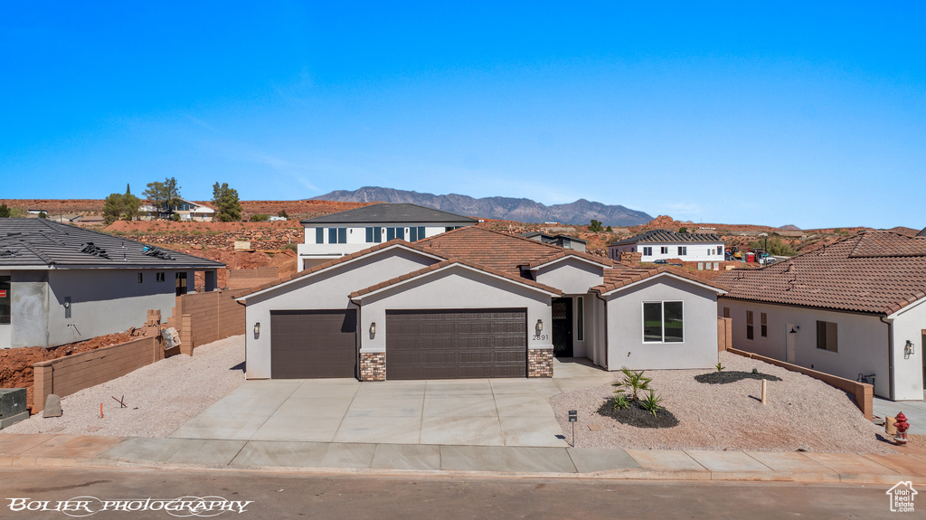 View of front facade with a garage and a mountain view