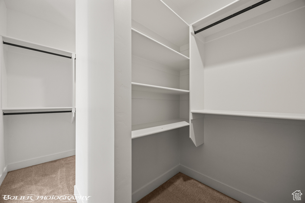 Walk in closet with light carpet