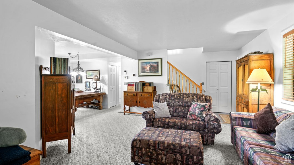 Carpeted living room featuring an inviting chandelier