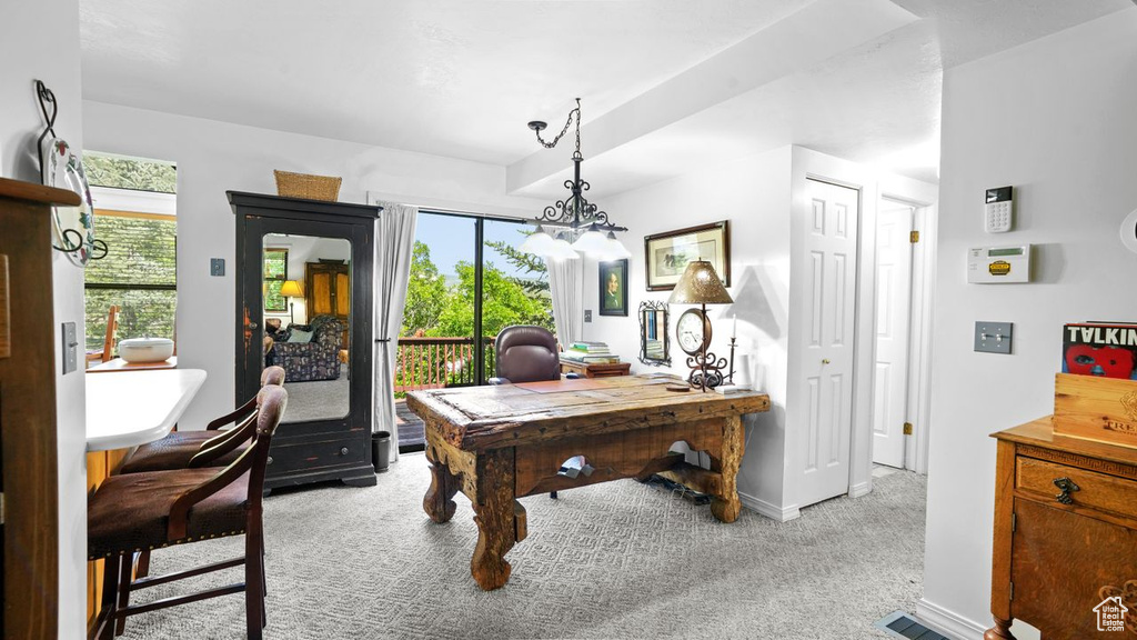 Carpeted office with a chandelier