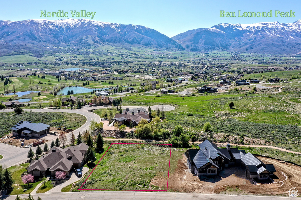 Birds eye view of property with a water and mountain view