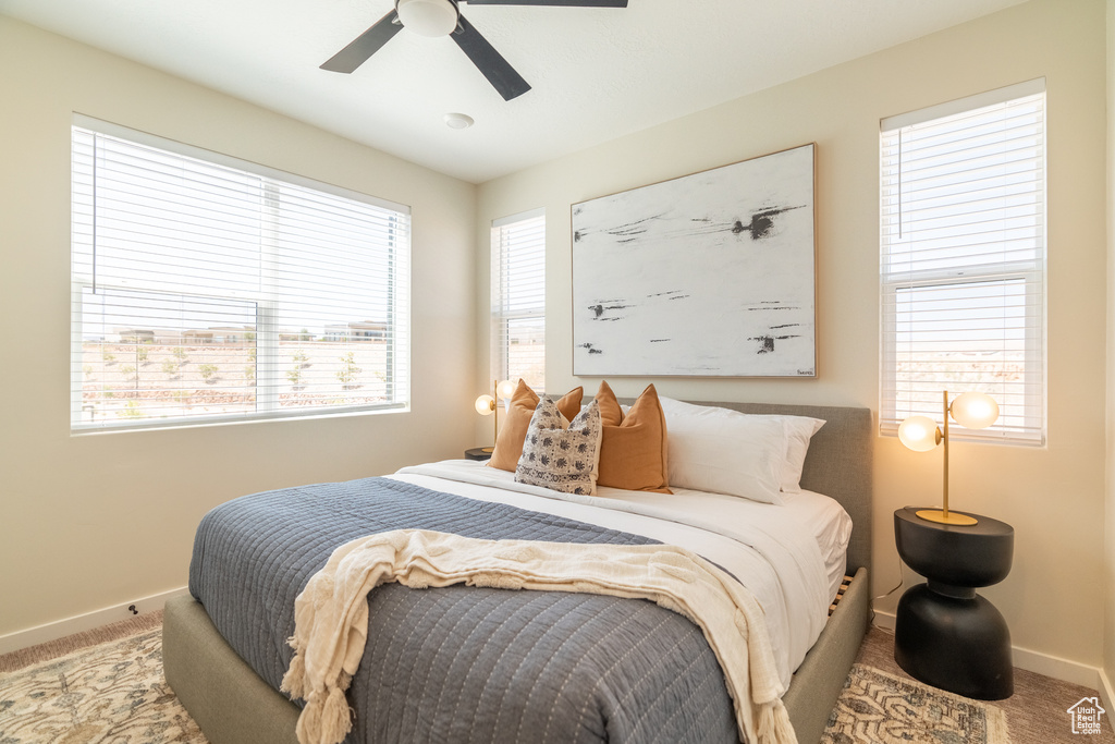 Carpeted bedroom featuring ceiling fan