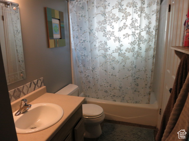 Full bathroom featuring vanity, toilet, and shower / bath combo with shower curtain