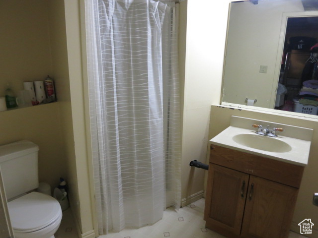 Bathroom featuring tile floors, toilet, and vanity