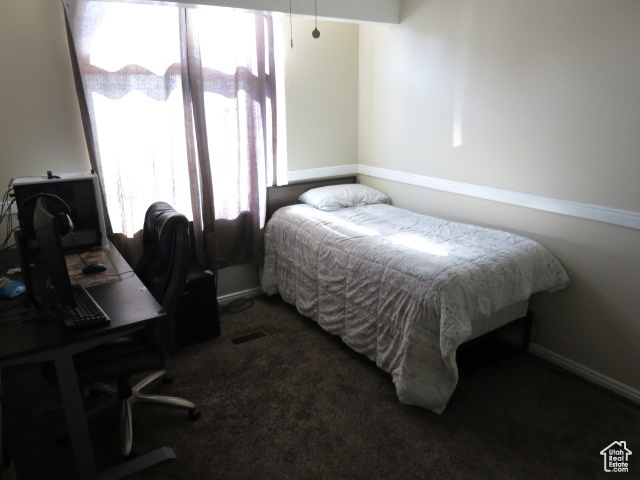 Bedroom featuring dark colored carpet