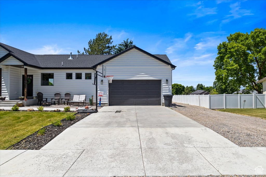 Single story home with a garage and a front yard