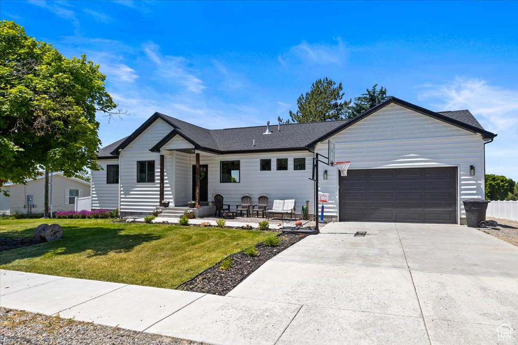 Ranch-style home featuring a front lawn and a garage