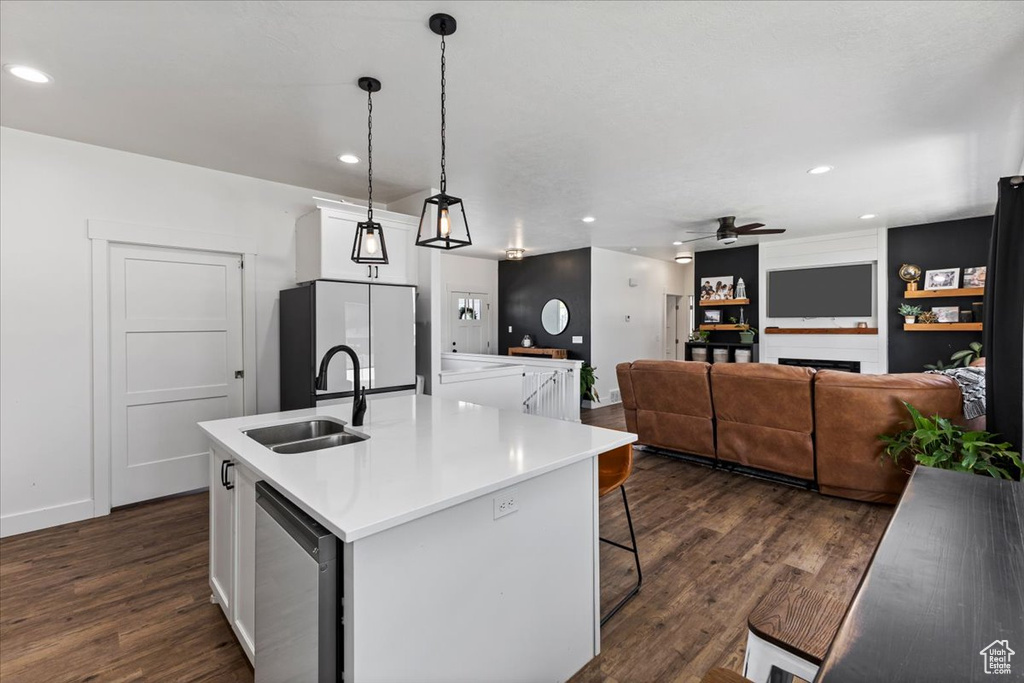 Kitchen featuring dark hardwood / wood-style flooring, white cabinets, decorative light fixtures, sink, and ceiling fan