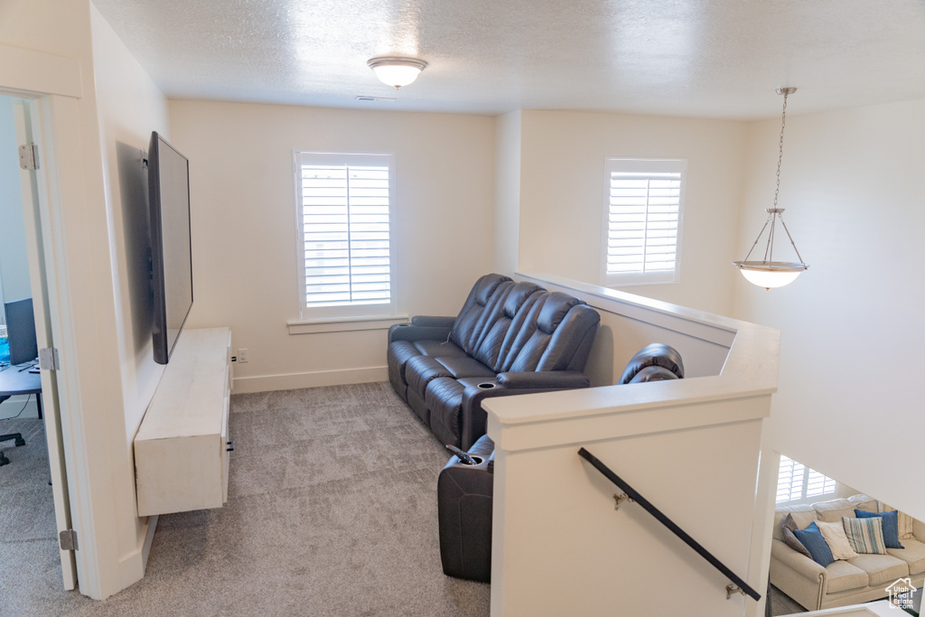 Living room with a textured ceiling and light colored carpet