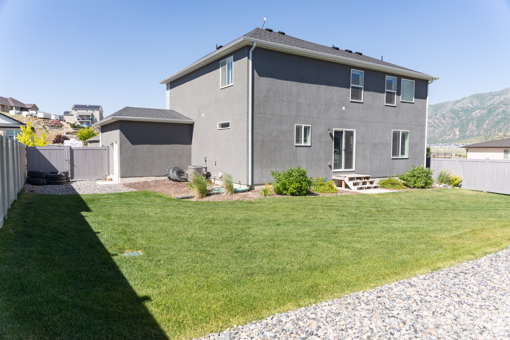 Rear view of property featuring a yard and a mountain view