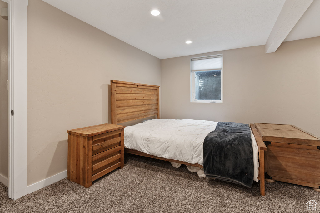 Bedroom with carpet flooring and beam ceiling