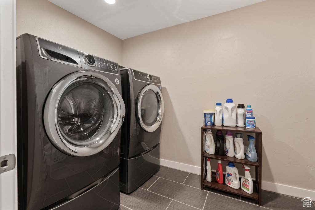 Clothes washing area featuring tile floors and washing machine and clothes dryer