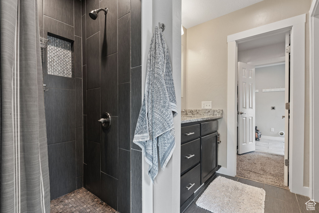 Bathroom with a shower with curtain, tile flooring, and vanity