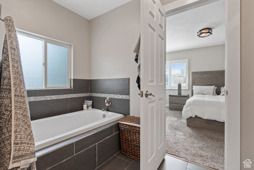 Bathroom featuring tile floors and tiled bath