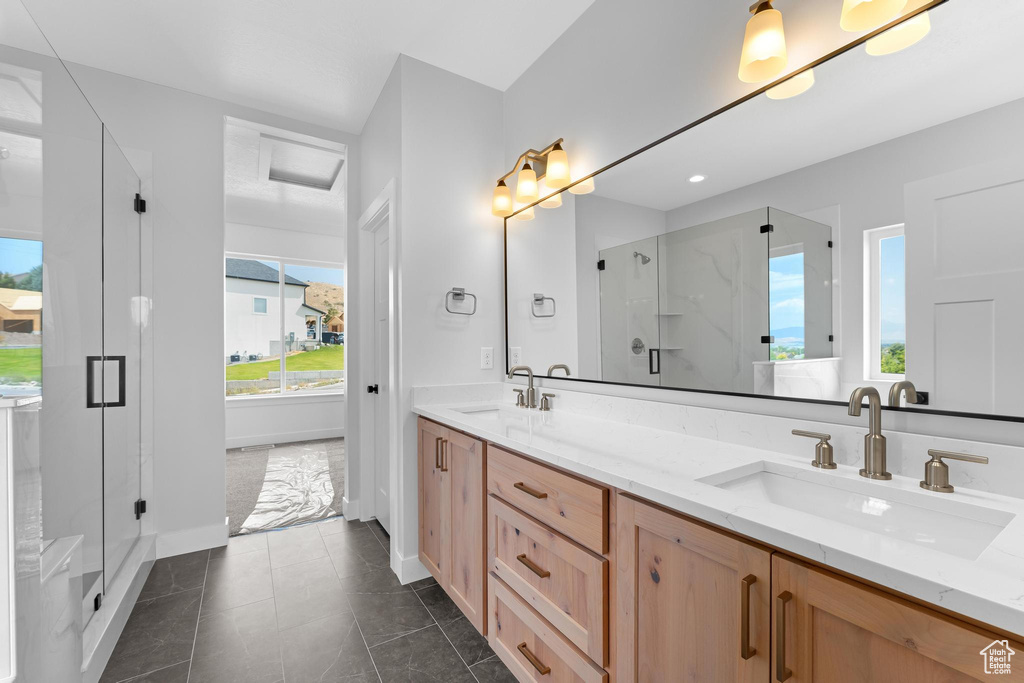 Bathroom with vanity, a shower with shower door, and tile patterned floors