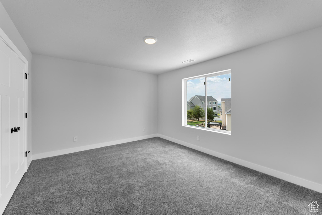 Carpeted spare room featuring a textured ceiling