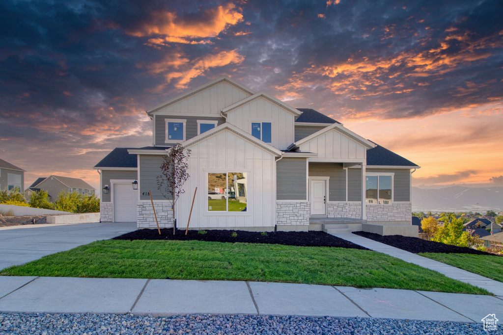 View of front facade featuring a yard and a garage