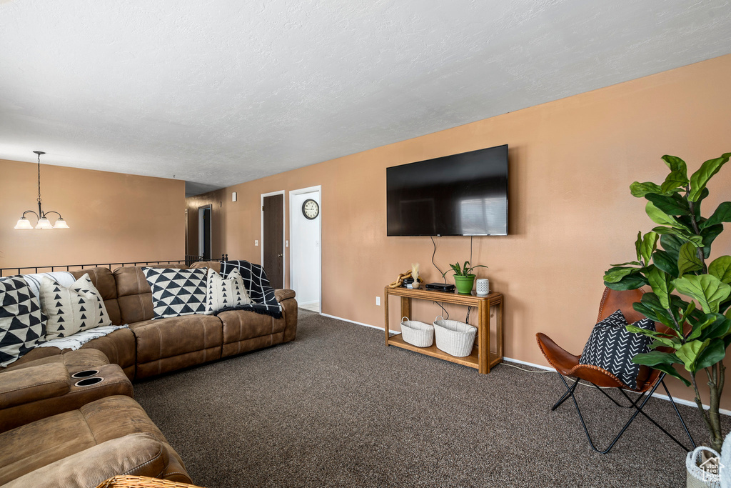 Living room featuring a chandelier and dark carpet