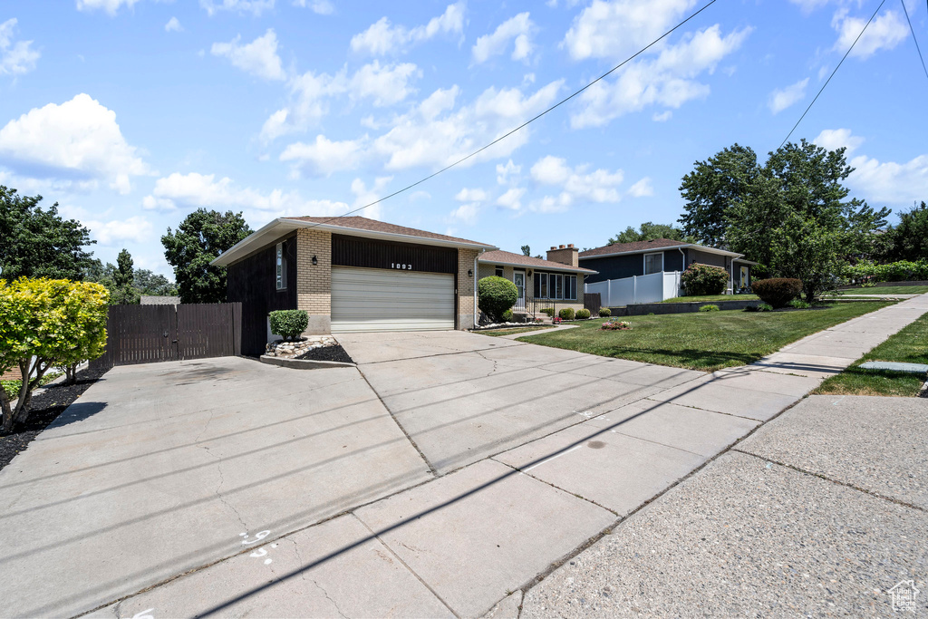 Single story home featuring a front yard and a garage