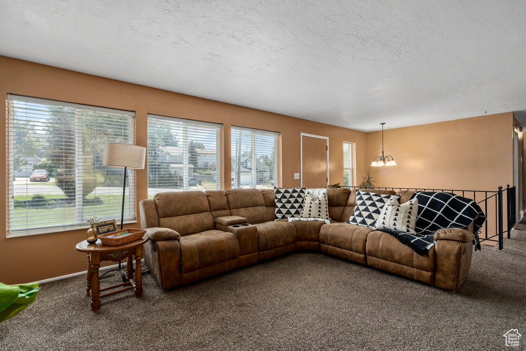 Carpeted living room with a chandelier and a textured ceiling