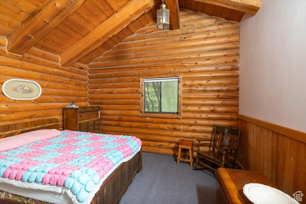 Carpeted bedroom featuring lofted ceiling with beams, log walls, and wood ceiling