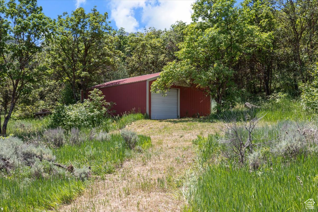 View of yard featuring a garage and an outdoor structure