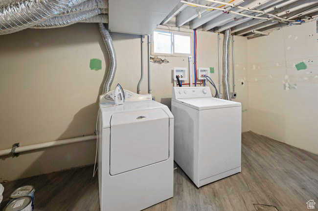 Clothes washing area featuring washer and dryer, wood-type flooring, and hookup for a washing machine