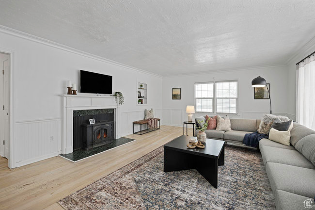 Living room with crown molding, a textured ceiling, and hardwood / wood-style floors