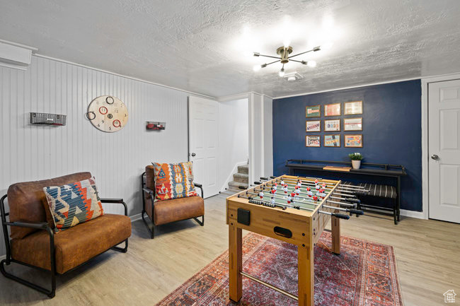 Recreation room featuring a textured ceiling and hardwood / wood-style flooring