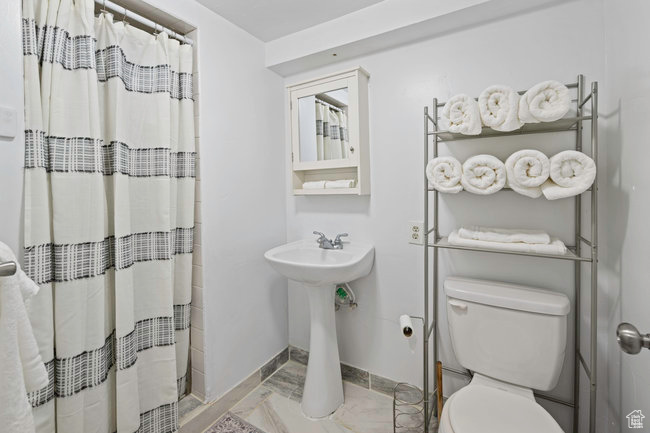 Bathroom featuring tile floors and toilet