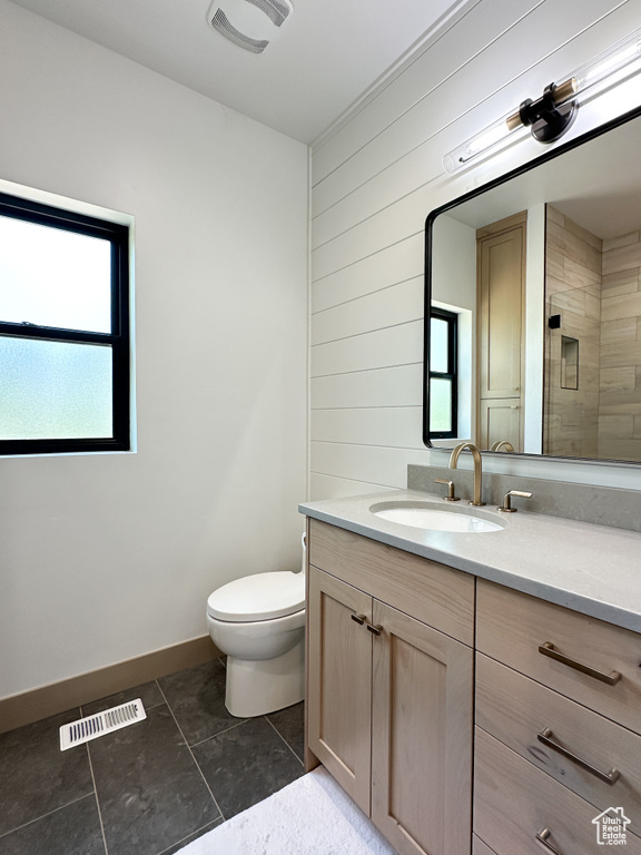 Bathroom featuring tile floors, plenty of natural light, toilet, and vanity