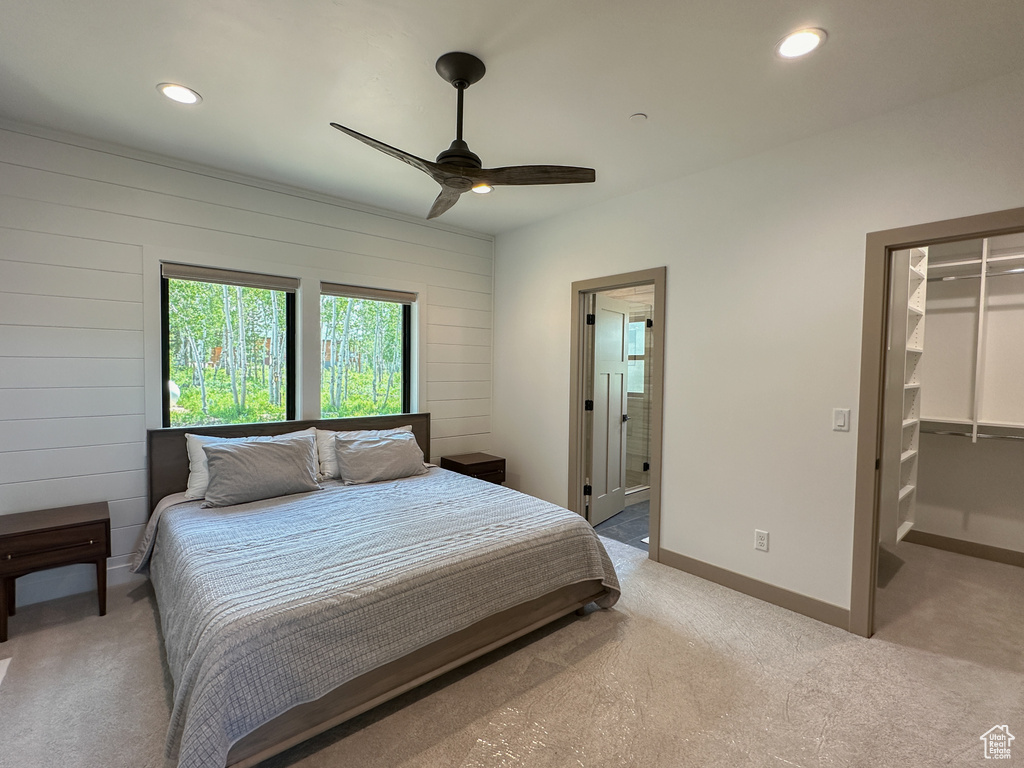 Bedroom featuring ceiling fan, a closet, a spacious closet, and carpet floors