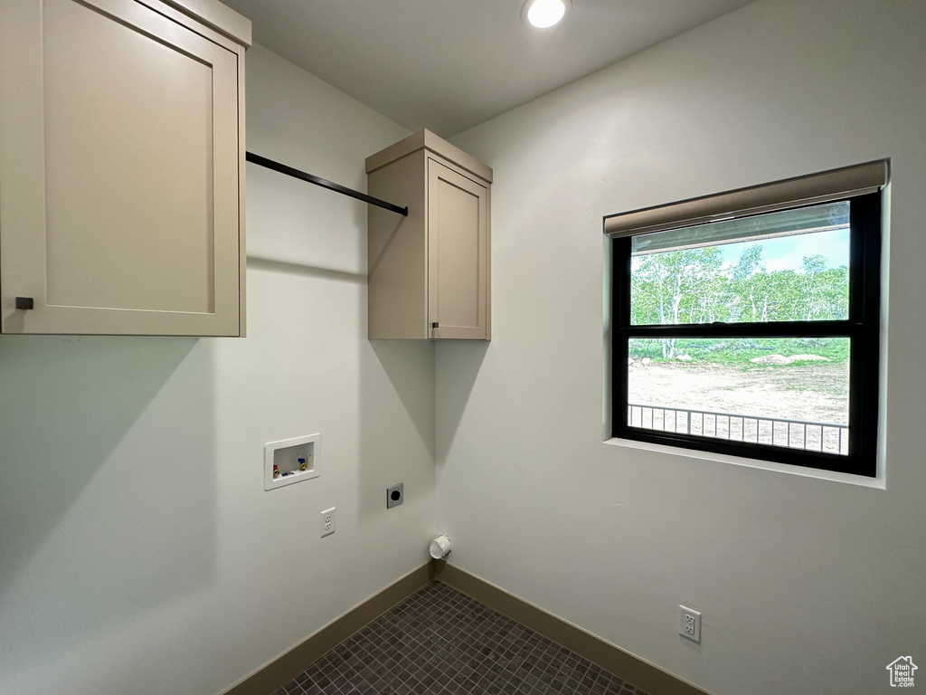 Laundry room featuring tile flooring, washer hookup, cabinets, and hookup for an electric dryer