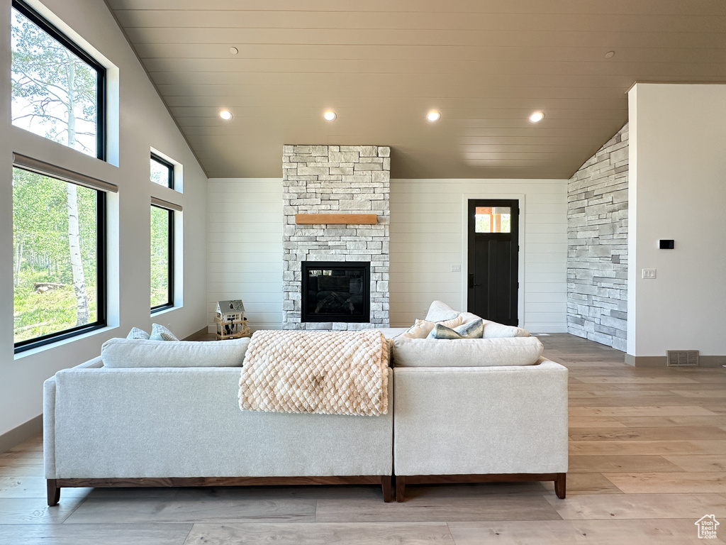 Living room with a fireplace, vaulted ceiling, and hardwood / wood-style floors