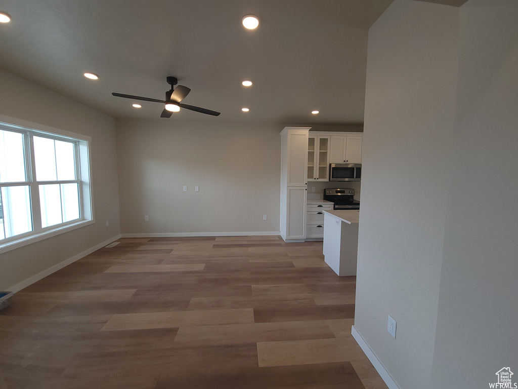 Unfurnished living room with wood-type flooring and ceiling fan