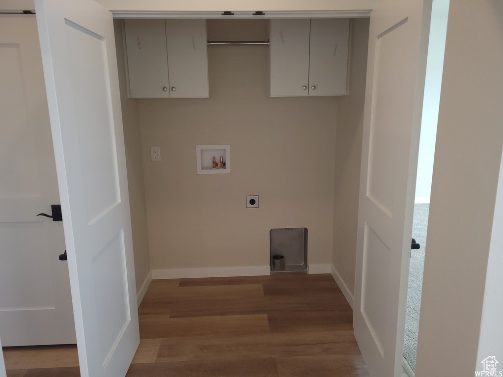 Laundry area with electric dryer hookup, hookup for a washing machine, hardwood / wood-style flooring, and cabinets