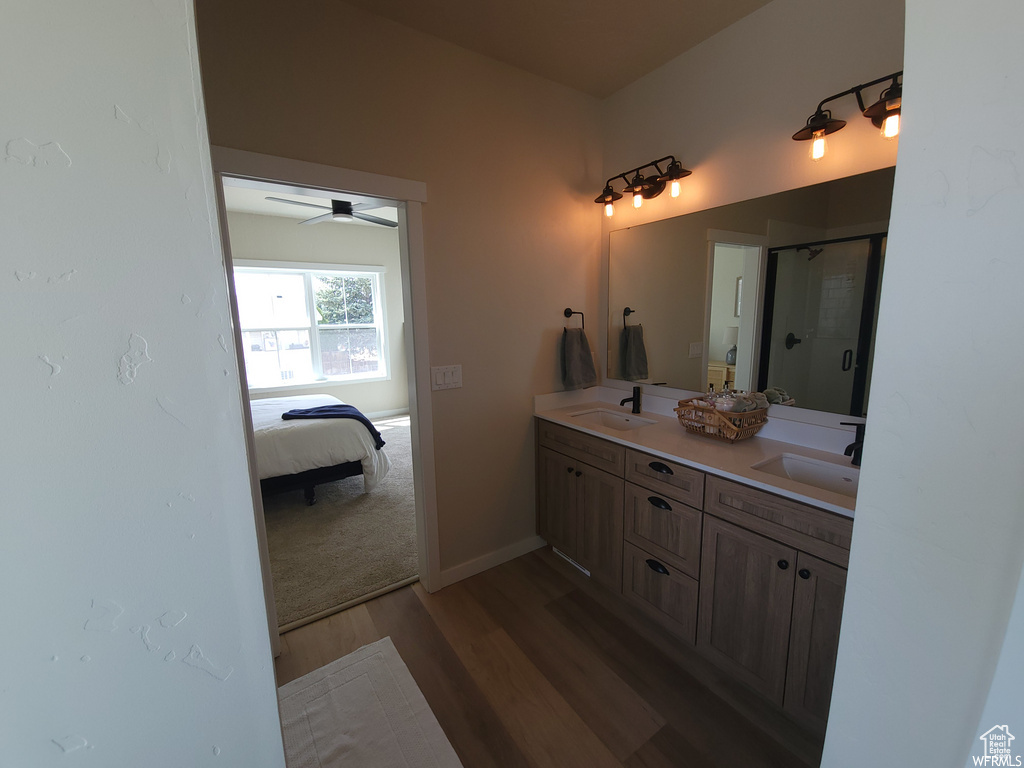 Bathroom featuring an enclosed shower, hardwood / wood-style flooring, dual vanity, and ceiling fan