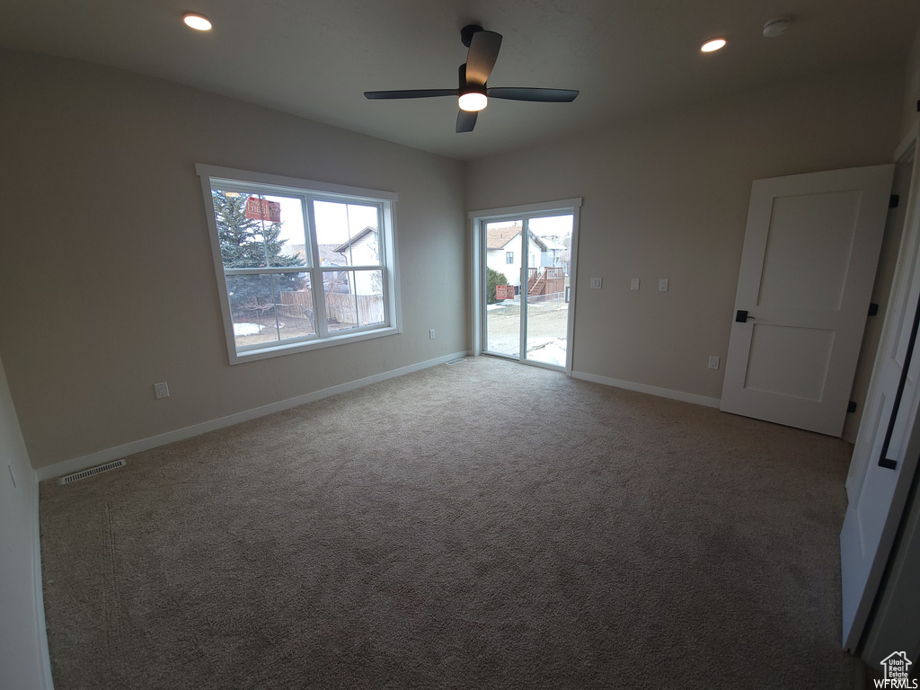 Carpeted empty room with ceiling fan