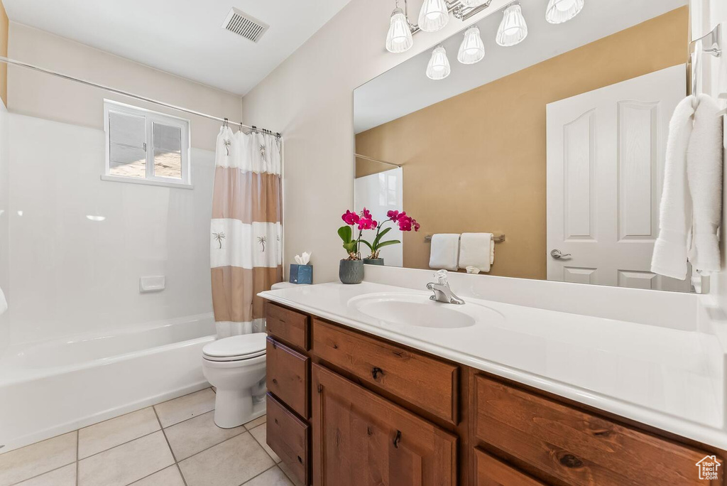 Full bathroom featuring tile floors, oversized vanity, toilet, and shower / tub combo