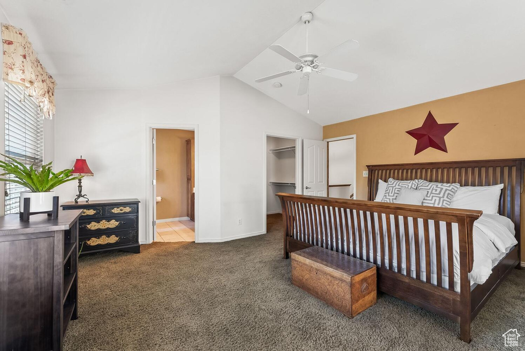 Bedroom featuring ceiling fan, ensuite bathroom, lofted ceiling, and carpet flooring