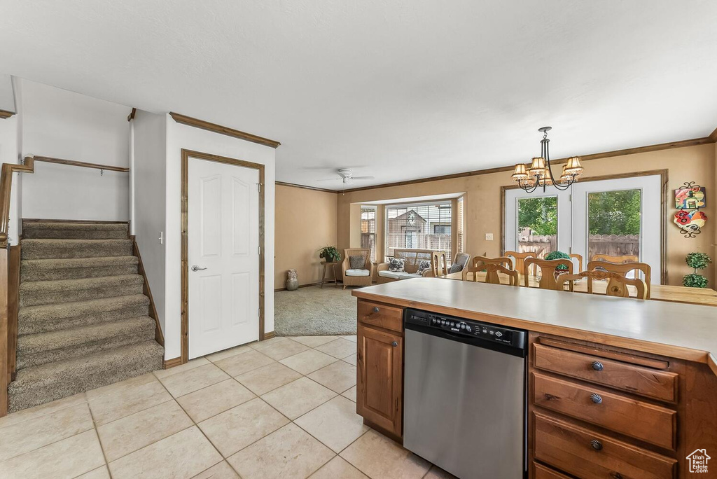 Kitchen featuring dishwasher, light tile flooring, crown molding, and pendant lighting