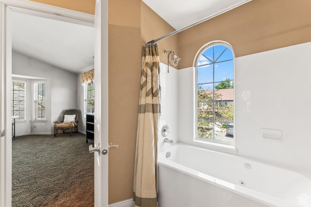 Bathroom featuring vaulted ceiling and shower / bath combo