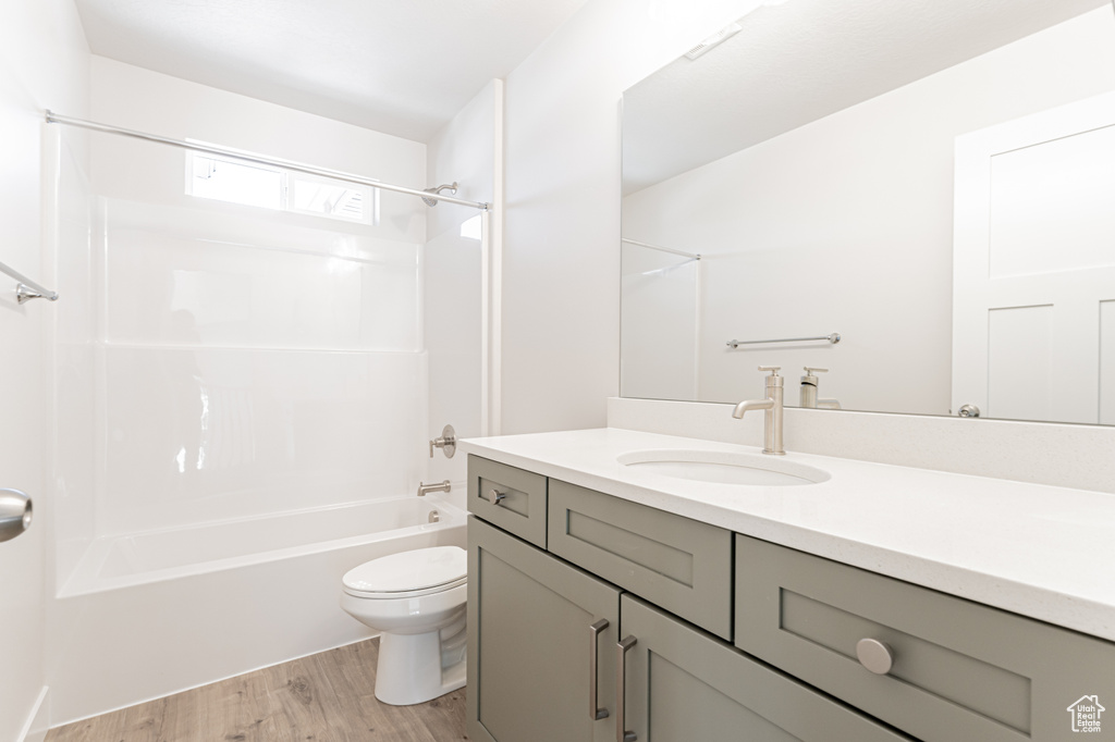 Full bathroom featuring vanity, hardwood / wood-style floors, toilet, and bathtub / shower combination