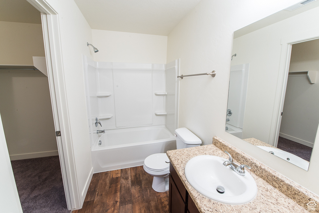 Full bathroom featuring bathtub / shower combination, vanity, toilet, and hardwood / wood-style floors