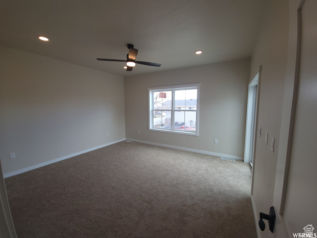 Empty room with ceiling fan and carpet floors