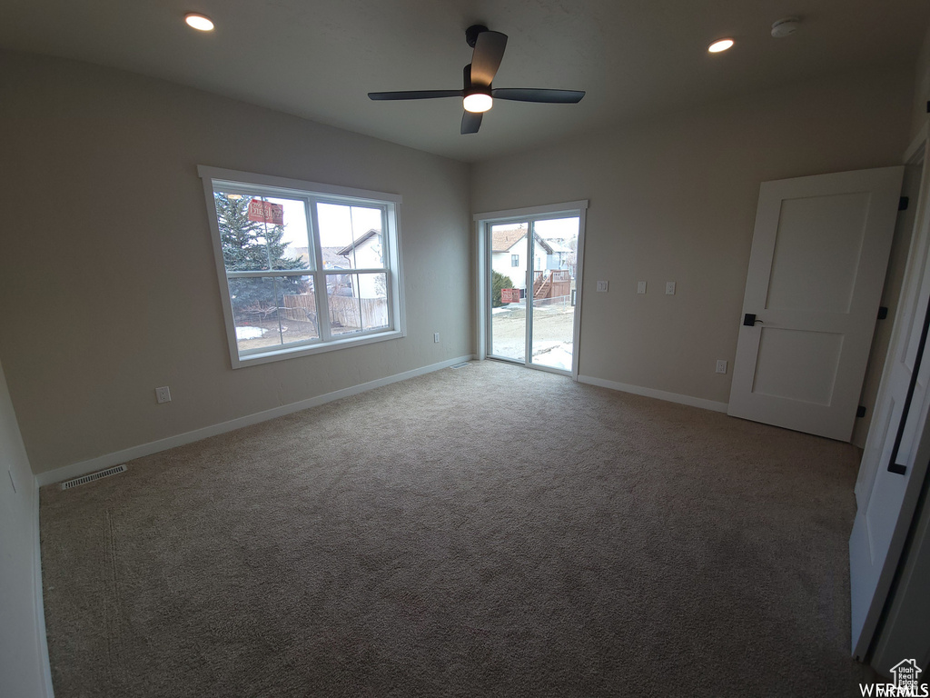 Empty room featuring ceiling fan and carpet floors